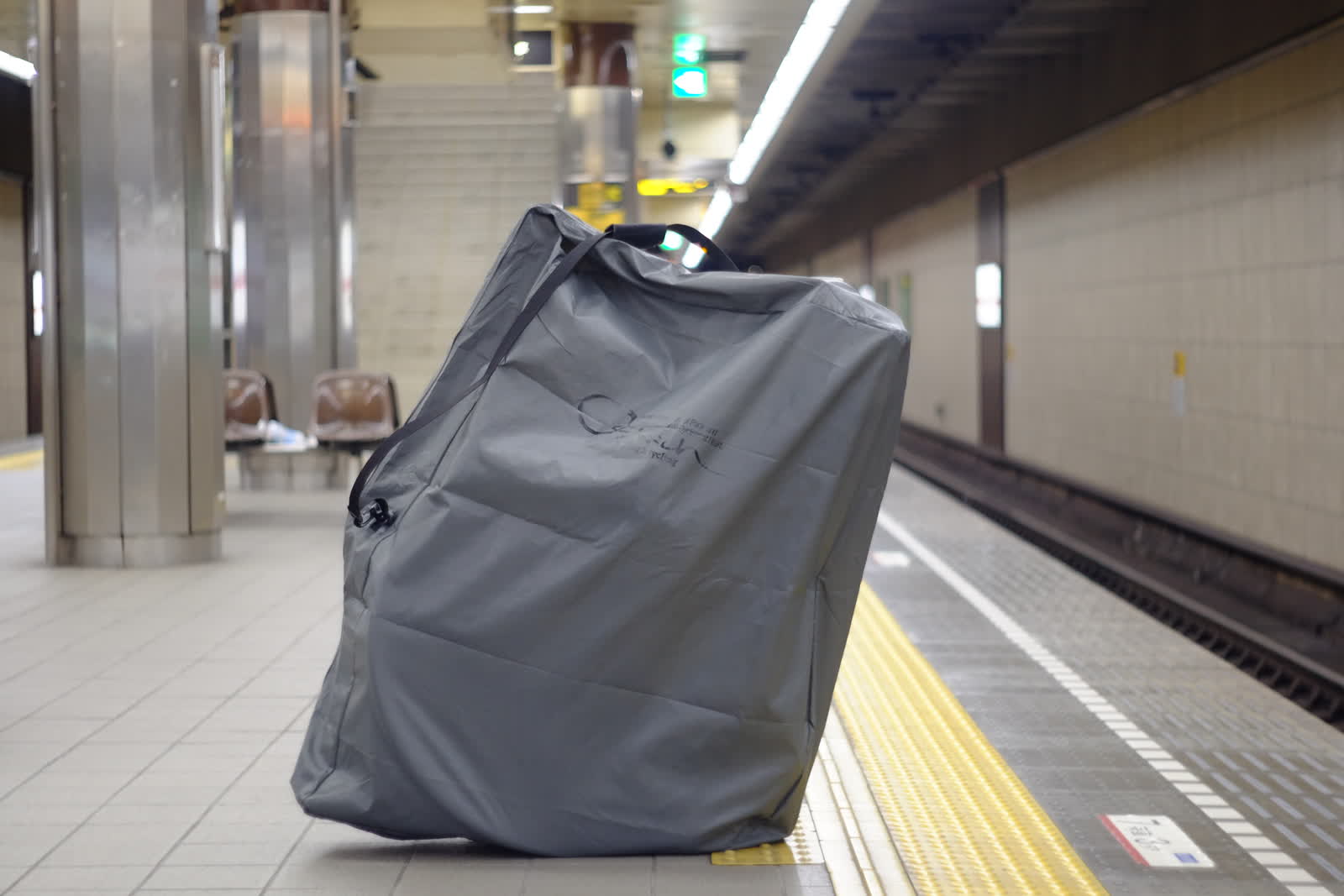 駅のホームで輪行袋に入れた自転車