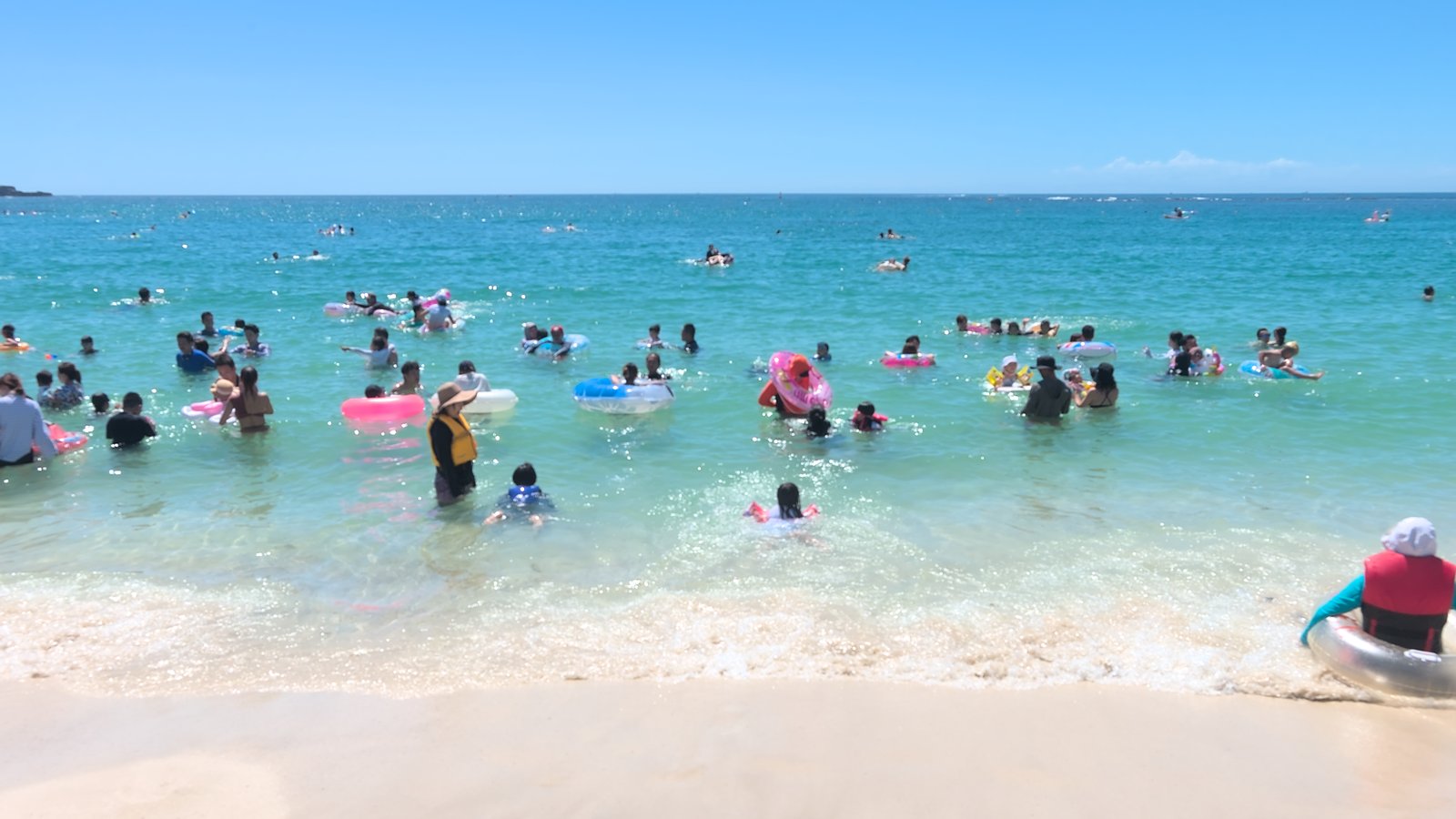 白良浜の海で泳ぐ人々