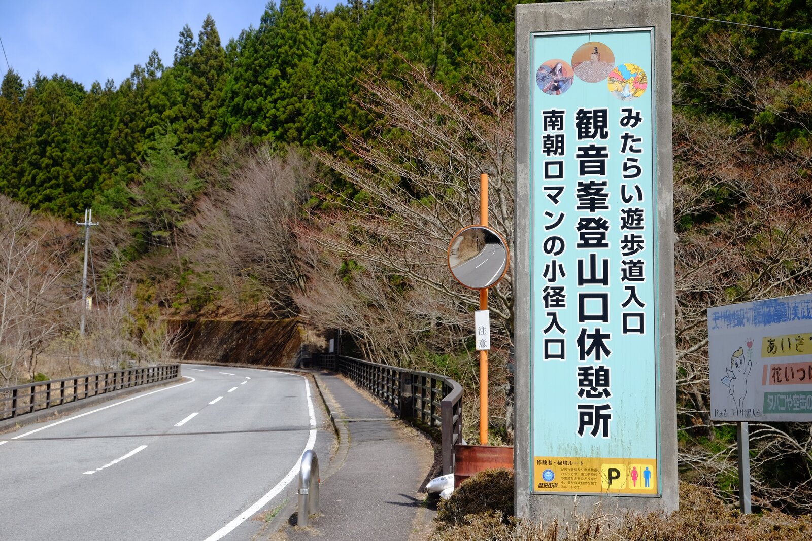 観音峯登山口休憩所の看板と車道