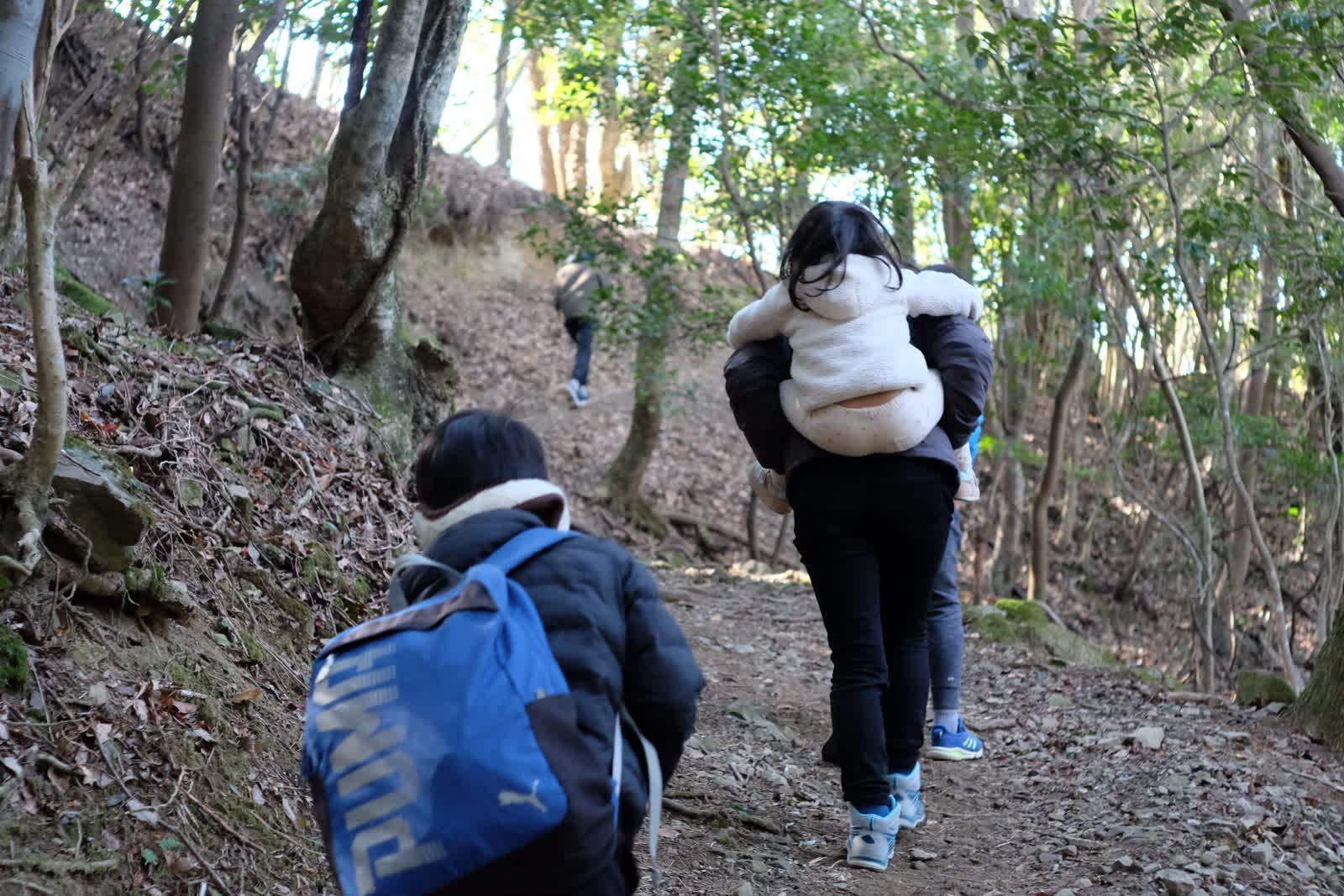 嫁さんが子供をおんぶして急坂を登る
